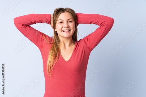 Teenager Ukrainian girl isolated on blue background laughing