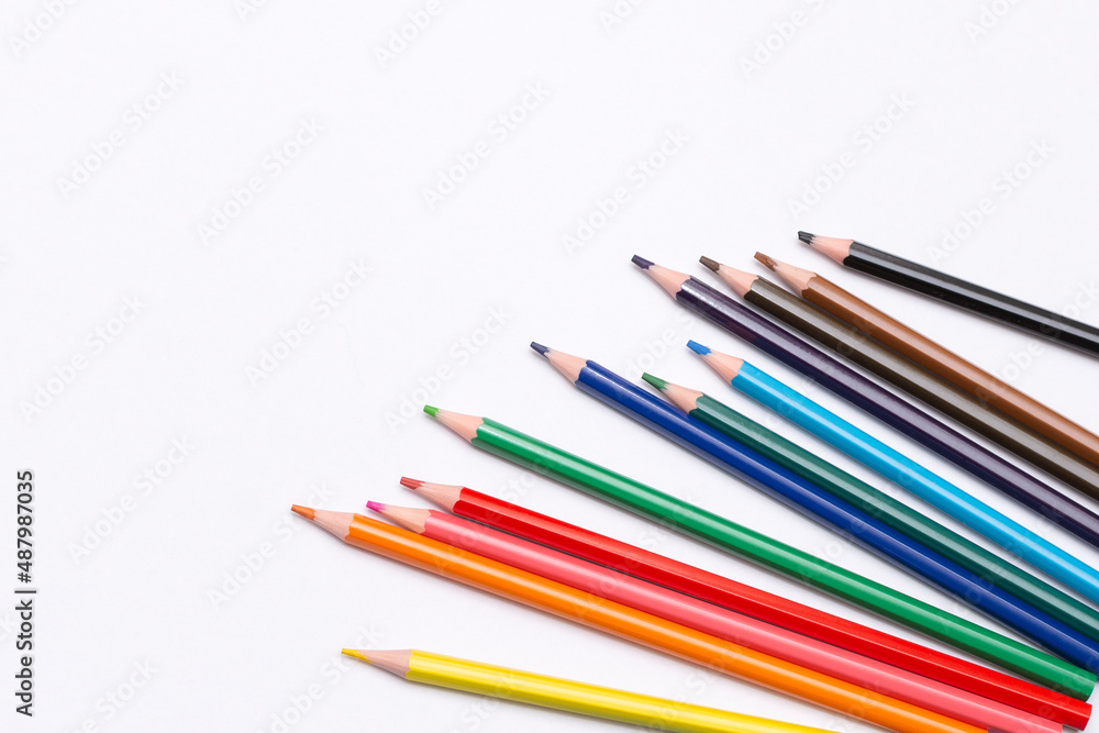 colored pencils are scattered on a white background. supplies for creativity and study colored pencils are scattered on a white background. supplies for creativity and study