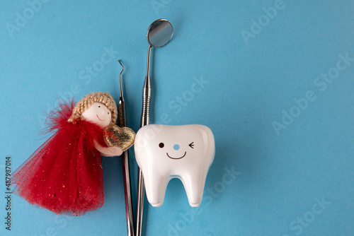 tooth Fairy. tooth figurine and tooth fairy nearby and dentist tools top view top view. Copy space Signboard for stomatology, dentist office or denal care clinic. oral hygiene. Holistic approach, heal photo