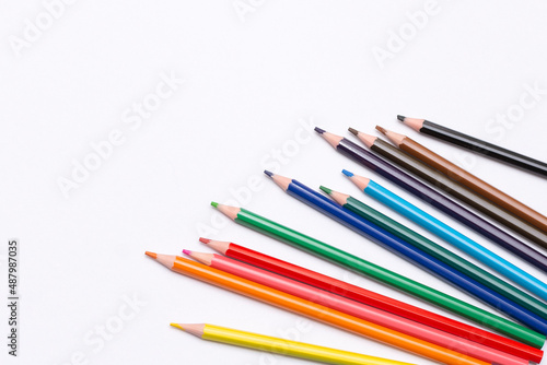 colored pencils are scattered on a white background. supplies for creativity and study