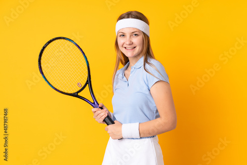Teenager Ukrainian girl tennis player isolated on yellow background © luismolinero