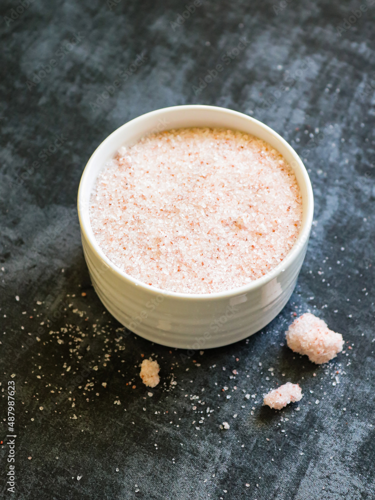 Himalayan pink salt in a bowl against dark background Himalayan pink salt in a bowl against dark background