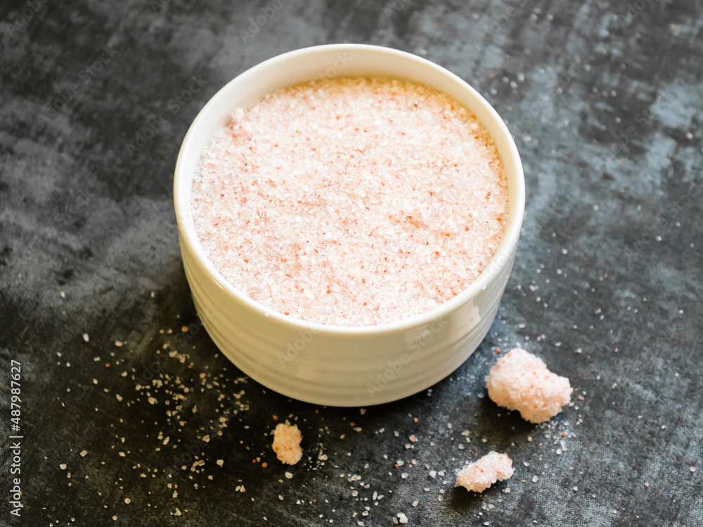 Himalayan pink salt in a bowl against dark background Himalayan pink salt in a bowl against dark background