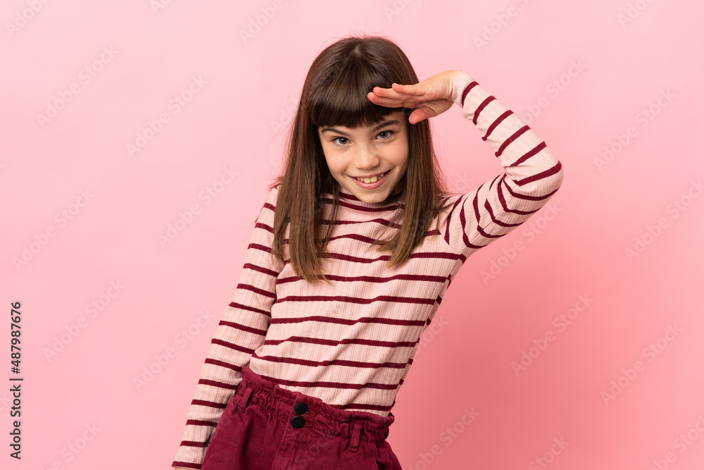 Little girl isolated on pink background saluting with hand with happy expression Little girl isolated on pink background saluting with hand with happy expression