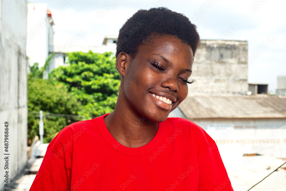 beautiful girl standing on the balcony of the house while smiling. beautiful girl standing on the balcony of the house while smiling.