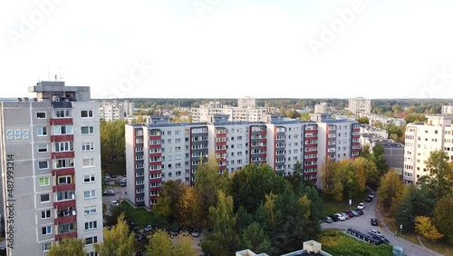 Renovated concrete apartment building in Kaunas city on sunny day, aerial descend shot photo