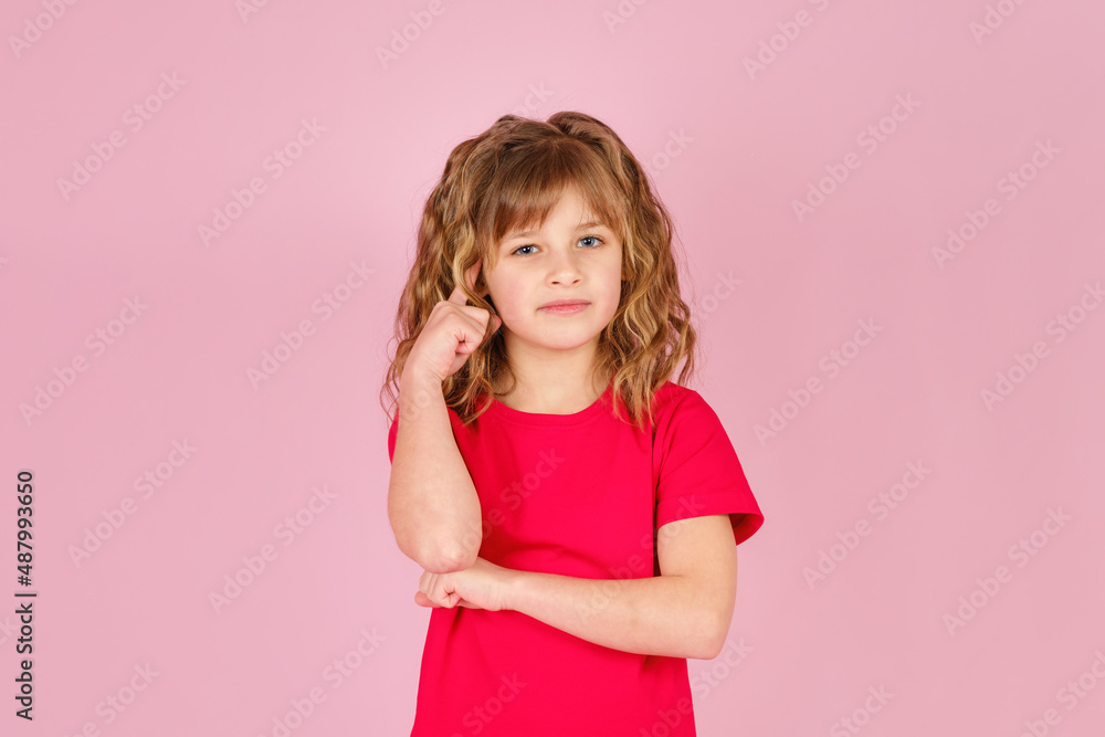 Portrait of cute curious little girl in red t-shirt isolated on pink background Portrait of cute curious little girl in red t-shirt isolated on pink background