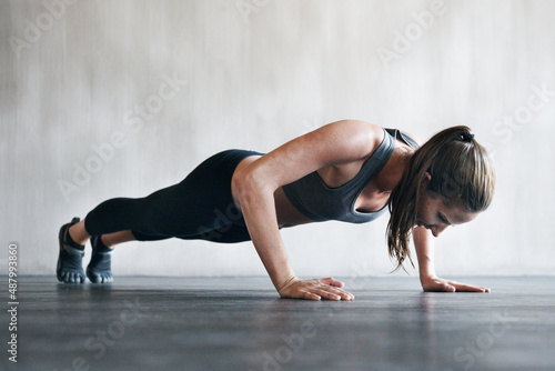 Shes taking this workout to the next level. Shot of a woman doing pushups at the gym.