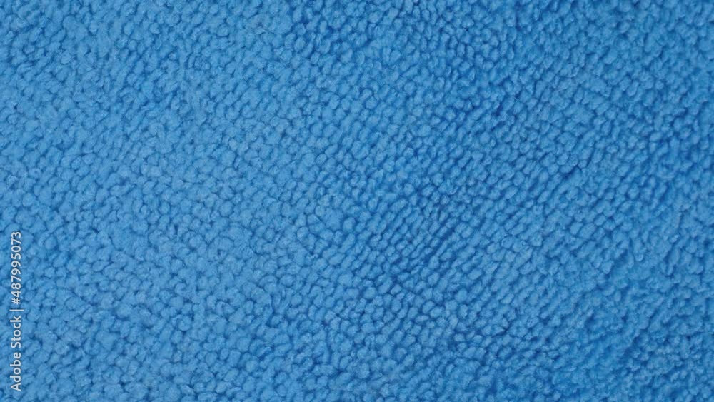 Close up: blue microfiber cleaning cloth on rotating surface - macro, top view. Abstract, pattern, texture, background and cleaning equipment for housework concept Close up: blue microfiber cleaning cloth on rotating surface - macro, top view. Abstract, pattern, texture, background and cleaning equipment for housework concept