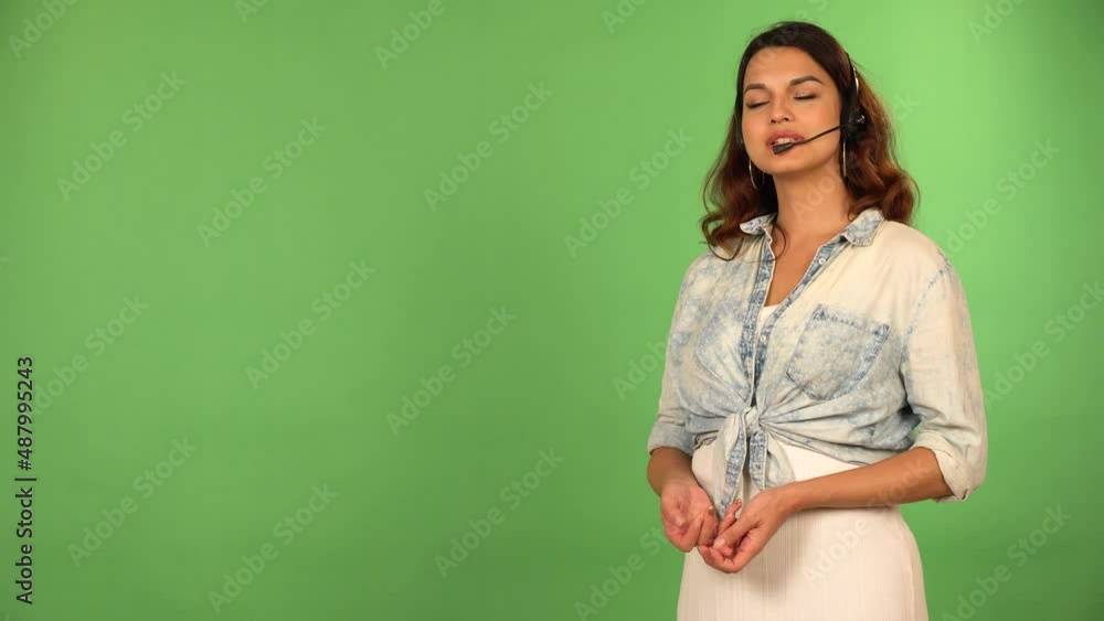 A young beautiful female technical assistant talks to the camera - green screen background A young beautiful female technical assistant talks to the camera - green screen background