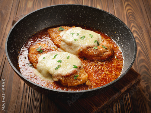 Frying pan with freshly cooked chicken parmesan photo