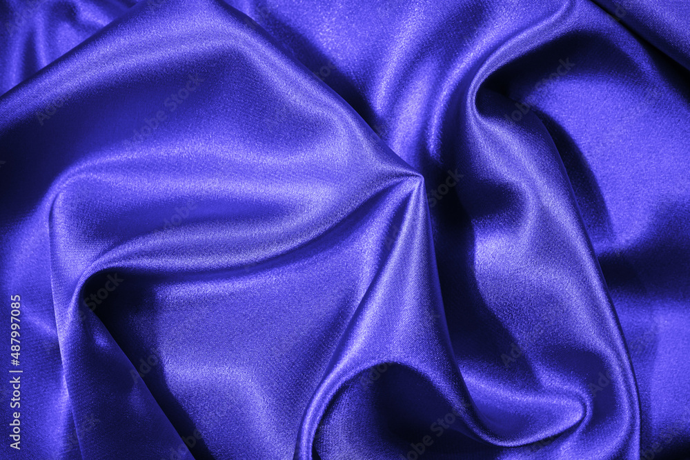 Fototapeta premium Purple blue silk satin. Beautiful soft folds. Shiny fabric surface. Elegant silky background with space for design. 