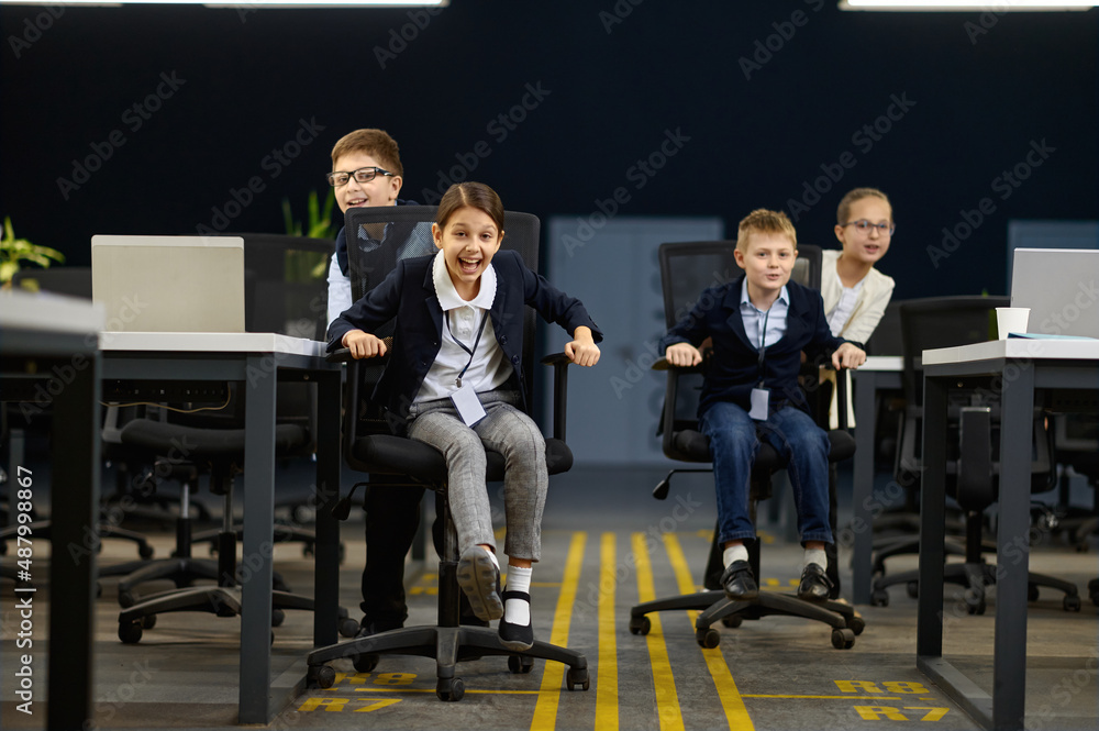Fototapeta premium Business children having fun riding office chair