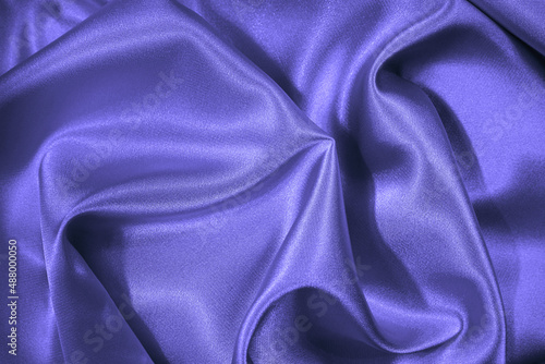 Purple blue silk satin. Beautiful soft folds. Shiny fabric surface. Elegant background with space for design. Very Peri. Color of the year 2022.