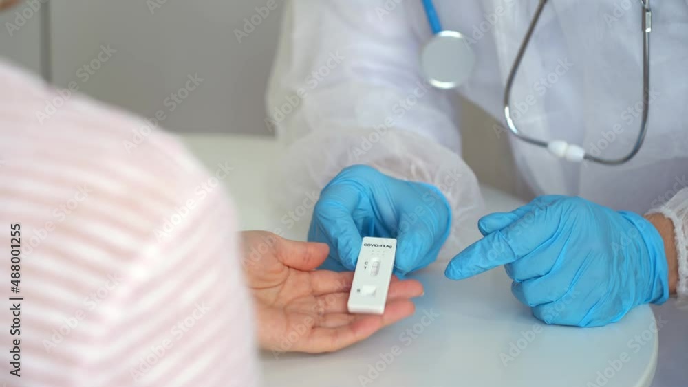 Doctors give rapid antigen test for covid-19 to female patient in clinic. Results of research on coronavirus test. Quick swab method to SARS-CoV-2. PCR Doctors give rapid antigen test for covid-19 to female patient in clinic. Results of research on coronavirus test. Quick swab method to SARS-CoV-2. PCR