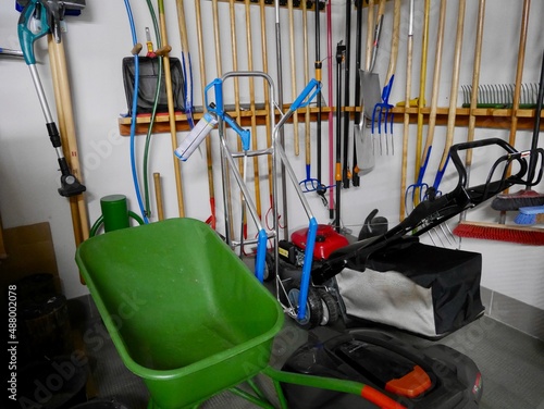 Gardening tools hanging on the wall in a tool shed.