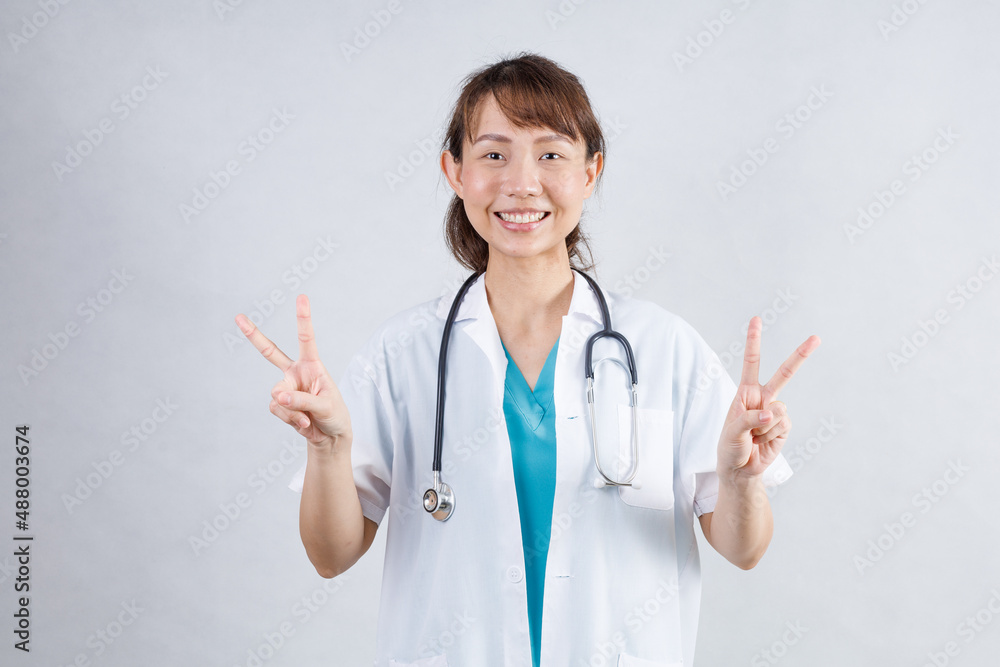 Happy beautiful female doctor in medical coat standing with crossed arms isolated on white.Asia look Happy beautiful female doctor in medical coat standing with crossed arms isolated on white.Asia look