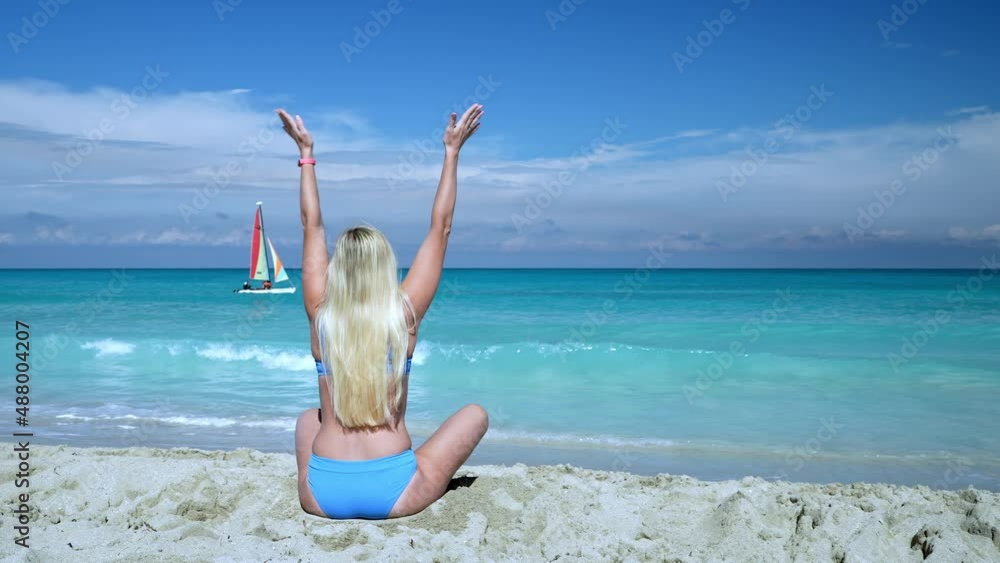 Beautiful blonde woman sitting in a meditation position on an Indian beach in a lotus position Beautiful blonde woman sitting in a meditation position on an Indian beach in a lotus position