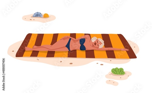 Pretty blonde sunbathing on the beach. Tropical resort leisure, summer vacation travel and holidays leisure. Young woman lying on towel on beach, girl relaxing and sunbathing on hot seacoast sand