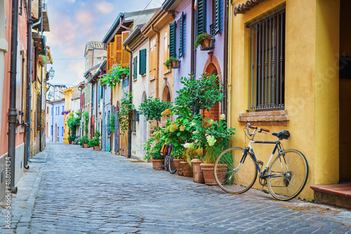 Fototapeta Naklejka Na Ścianę i Meble -  Narrow street of the village of fishermen San Guiliano with colorful houses and a bicycle in early morning in Rimini, Italy