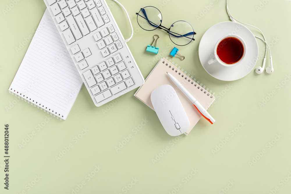 Light green office desk, minimalist style desk with keyboard, tea mug