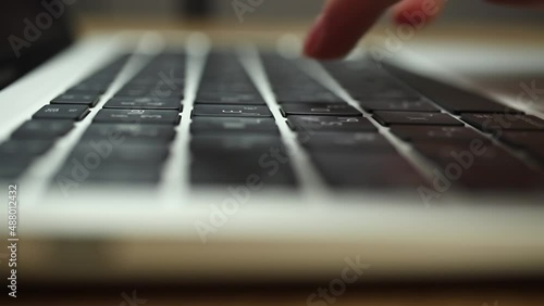 Close-up of woman hands typing on a laptop keyboard. Slow motion footage