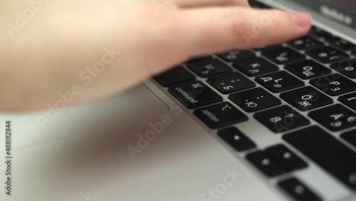 Close-up of woman hands typing on a laptop keyboard. Slow motion footage