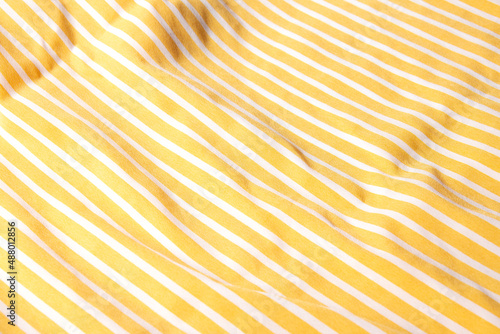 Beautiful yellow fabric with white stripes background. Draped background of fabric, texture. Abstract background
