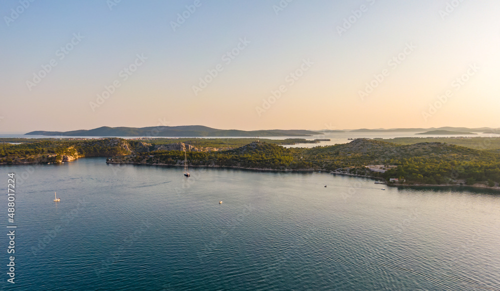 Aerial drone view of sunset over Kornati islands near the Sibenik city, Croatia. Water bay with boats ans soft sun light.