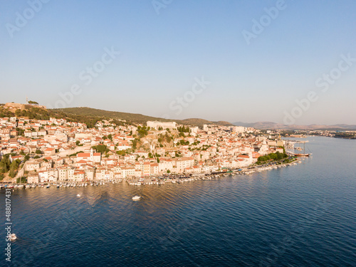 Fototapeta Naklejka Na Ścianę i Meble -  Aerial dronw view of sunset over the Sibenik city, Croatia. Ancient and old town coastline with harbor near the sea. Fortress above the city. Famous tourist destination in Croatia.