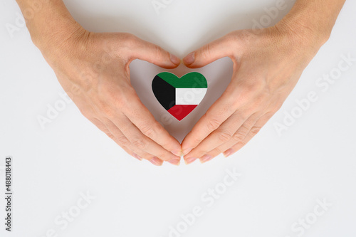 The national flag of Kuwait in female hands.