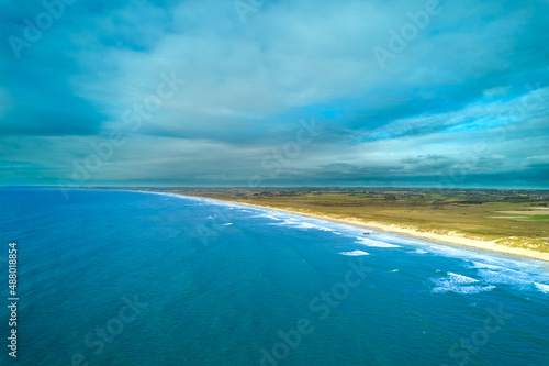 Fototapeta Naklejka Na Ścianę i Meble -  Aerial view of french beach in the brittany. Sea with waves in rural area. Vacation in Tronoan, near La torche in France. Colorful Landscape.