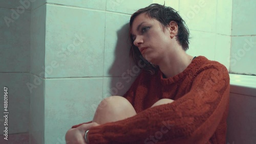 immobility, sadness - depressed girl unable to react curled up in the bathroom