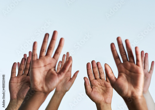 Raise your hands in support of each other. Shot of a group of hands reaching up against a white background.