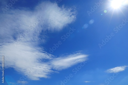 Clear blue sky with white clouds and sun in summer time. Nature background concept. © Aungsumol