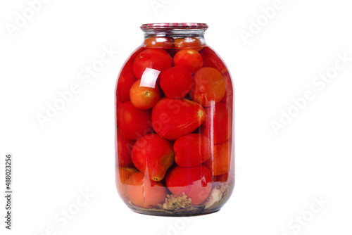 a large glass jar with canned red tomatoes