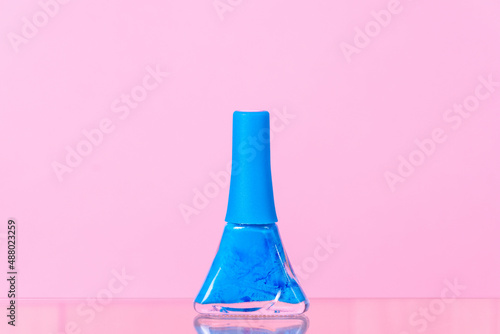 blue nail polish on a pink background