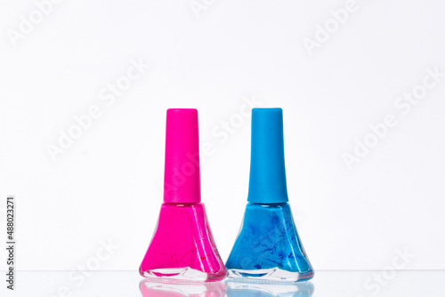 blue and pink nail polish on a white background
