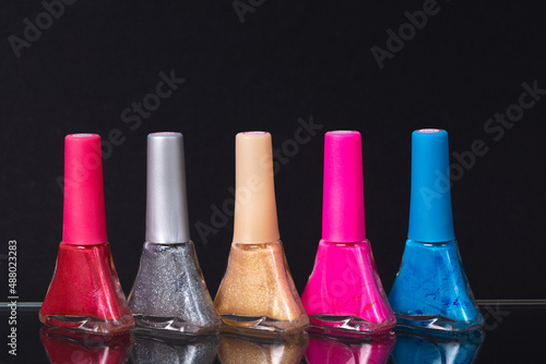 nail polish of different colors on a black background