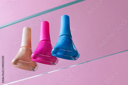 blue, gold and pink nail polish on a pink background