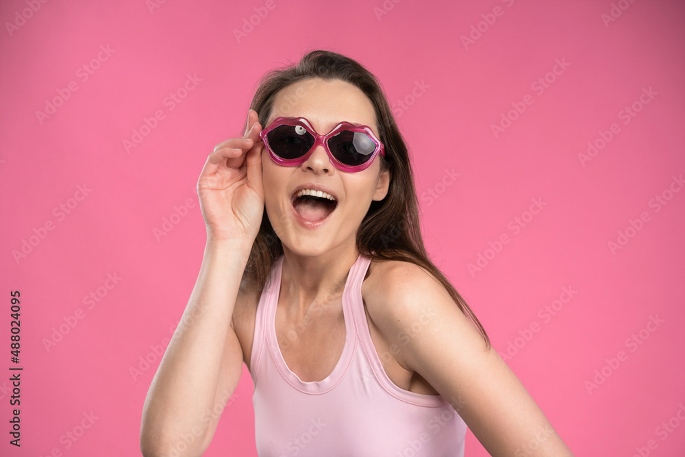 Stressed or having a headache businesswoman in suit holding her head with eyes shut isolated on pink background. Stressed employee woman in stripe suit Stressed or having a headache businesswoman in suit holding her head with eyes shut isolated on pink background. Stressed employee woman in stripe suit