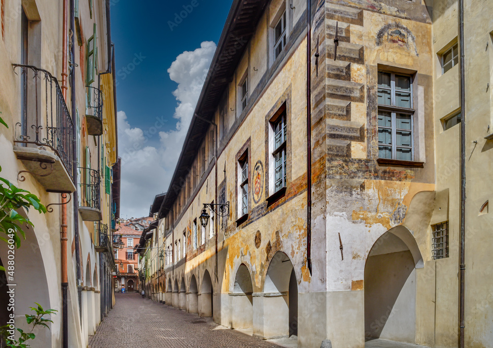 Saluzzo, Italy - May 06, 2019: Via Alessandro Volta (via de porti scur) with Palace of the Bishops in the foreground and other ancient buildings in the historic center