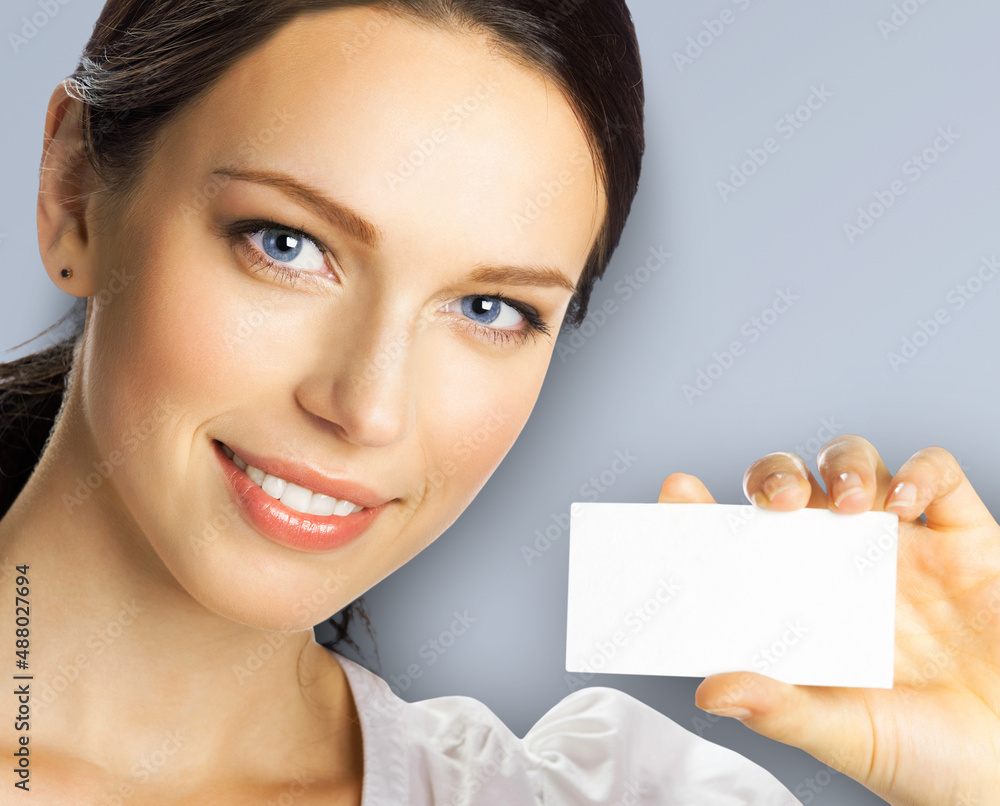 Closeup portrait of smiling businesswoman showing mockup empty businesscard or plastic credit card, with copy space for sign, over grey color background. Brunette business woman at studio image. Closeup portrait of smiling businesswoman showing mockup empty businesscard or plastic credit card, with copy space for sign, over grey color background. Brunette business woman at studio image.