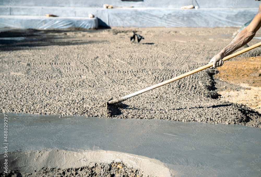 Dragging the concrete with a rake to distribute it and be able to smooth and draw later Dragging the concrete with a rake to distribute it and be able to smooth and draw later