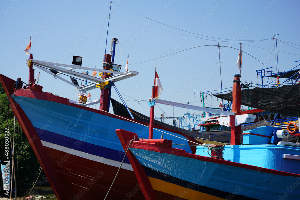 A wooden fishing boat is parked at the mouth or riverside of the Juwana River, Pati regency, Central Java, Indonesia.