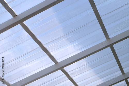 Under the structured white roof with sunlight and shadow