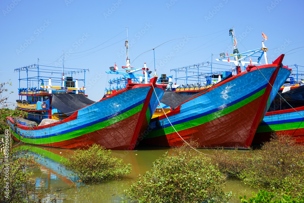 A wooden fishing boat is parked at the mouth or riverside of the Juwana River, Pati regency, Central Java, Indonesia.