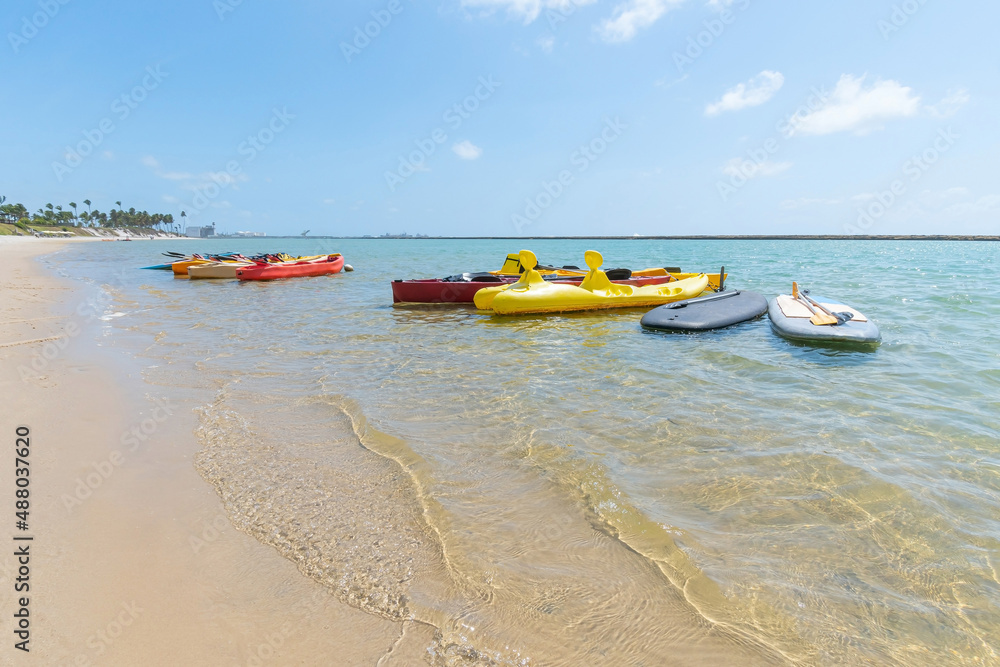 Fototapeta premium Kayaks at Muro Alto beach, tourist attraction of this famous beach of Ipojuca. Beach with no waves, warm and calm water surrounded by a reef wall.