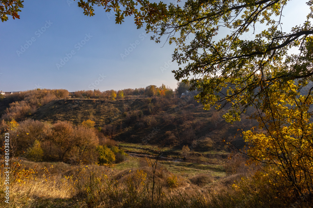 view from the hill to the valley of a stream in a ravine in autumn