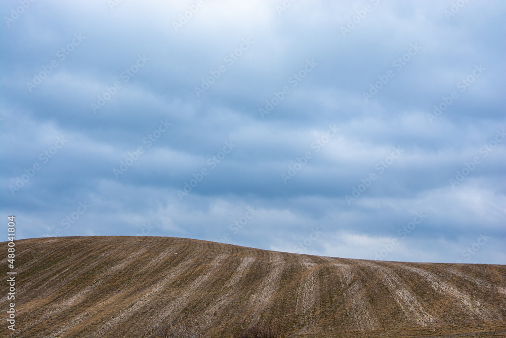 a deep blue sky above a field on a hill